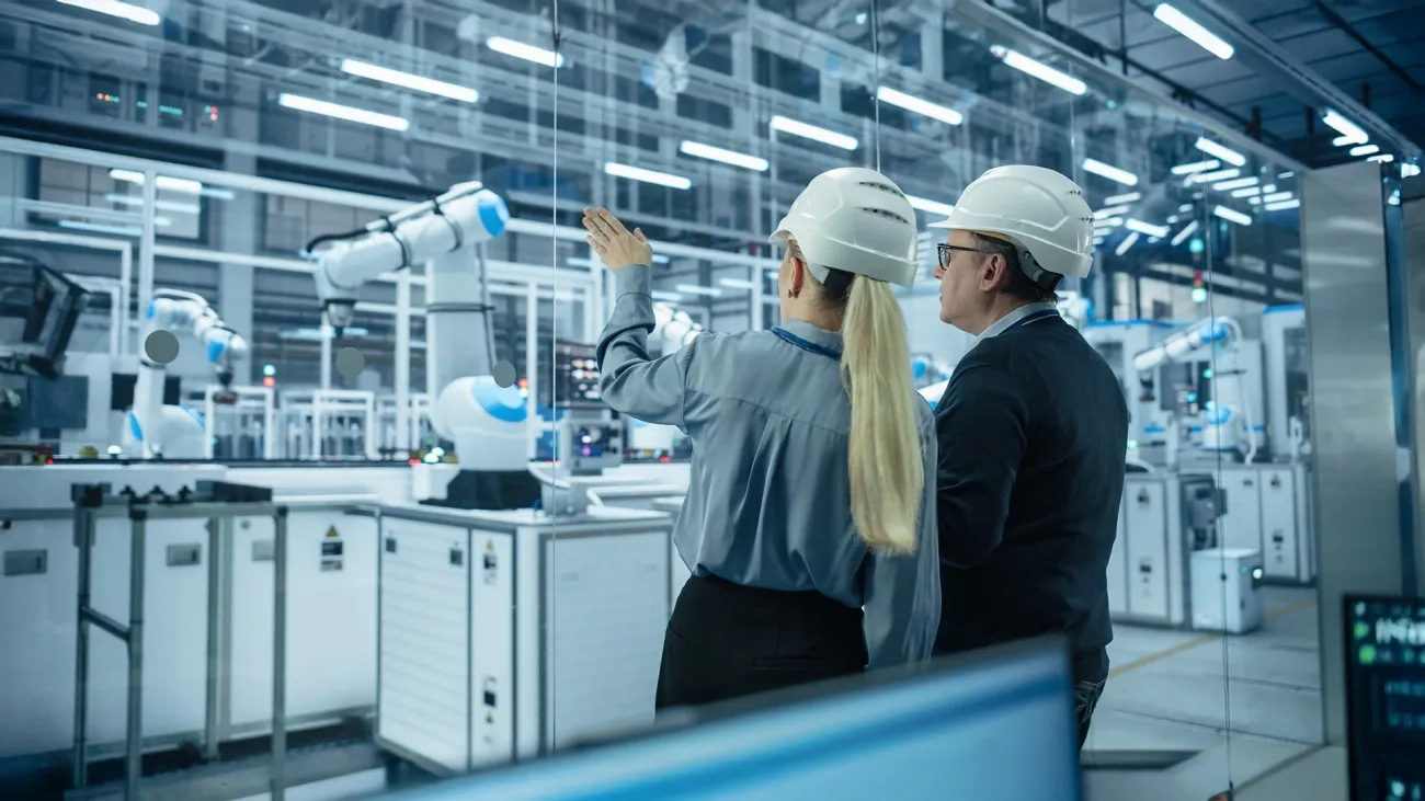 Two workers with hardhats looking at factory