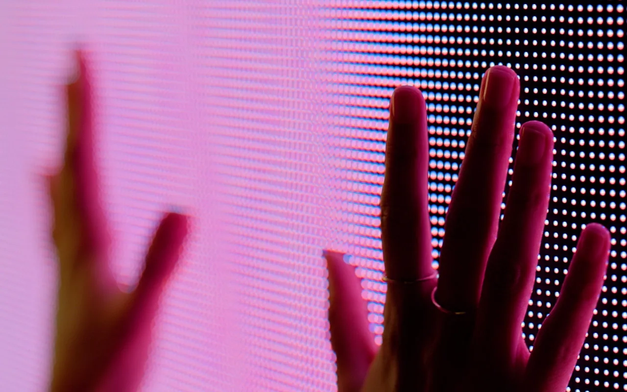 Human hands on a red colored screen 