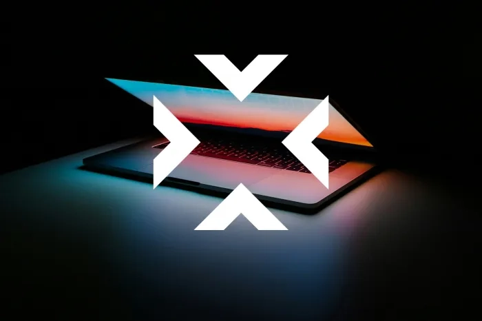 Laptop in the dark with four white arrows in the middle